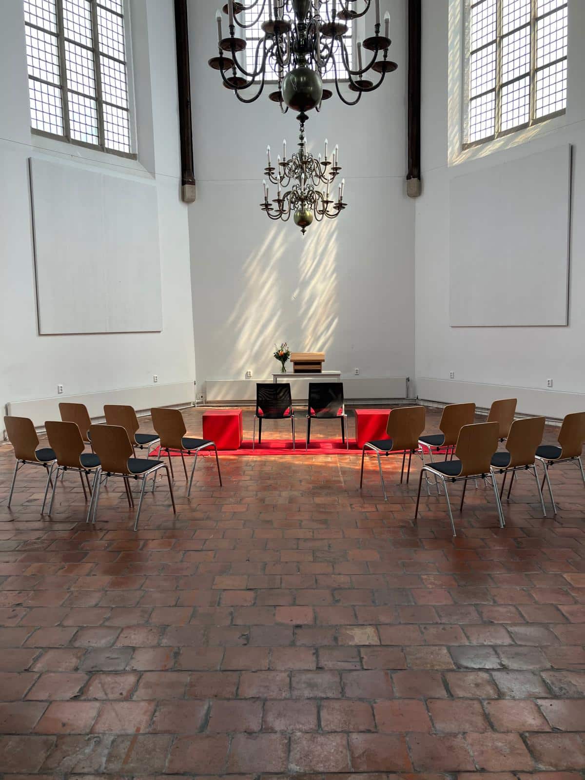 De foto laat de binnenkant van de Agnietenkapel zien. Er staan een aantal stoelen opgesteld met vooraan 2 stoelen voor het bruidspaar. Er staan geen mensen op de foto.