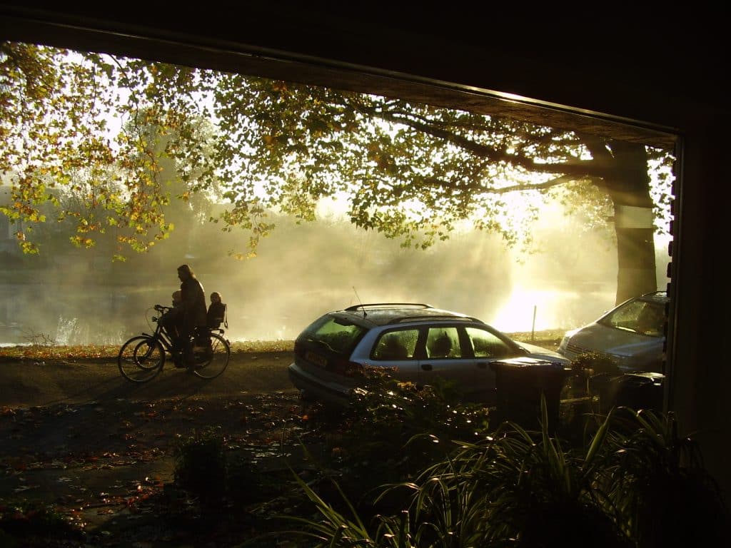 Een vrouw op de fiets die in de herfst over de Burgvlietkade fietst.