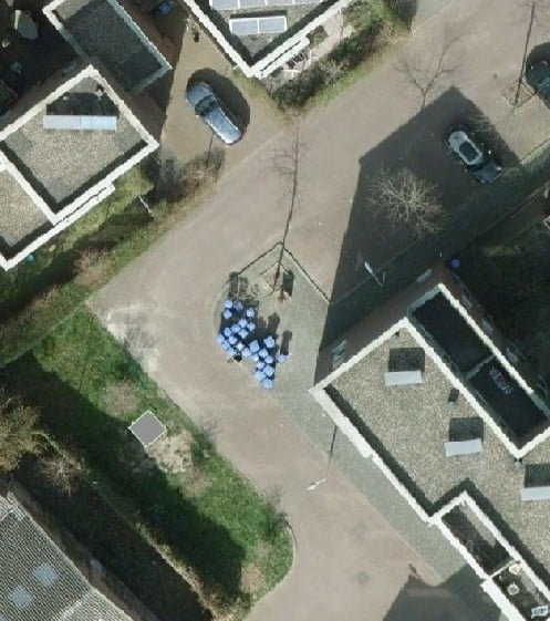 Een foto van bovenaf van de plek waar de ondergrondse restafvalcontainer komt in de wijk 
Nieuwe Park Oost. De ondergrondse restafvalcontainer wordt geplaatst op de Verspuystraat 8, op het stukje grasveld tegenover de verzamelplek op de hoek waar normaal gesproken de afvalcontainers worden geleegd. 