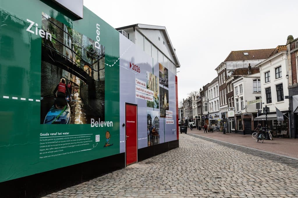 De bouwschutting is beplakt met posters die het verhaal van Gouda vertellen. 