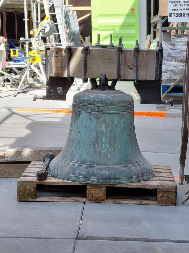 Op de foto is een ijzeren klok te zien op een pallet. We gaan de klok herstellen zodat deze er weer zo goed als nieuw uitziet.